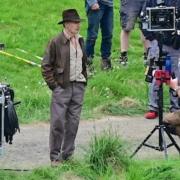 Harrison Ford  at the Leaderfoot Viaduct wearing his trademark leather jacket and fedora hat