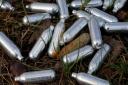 Canisters of nitrous oxide, or laughing gas, photographed discarded by the side of a road