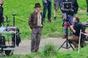 Harrison Ford  at the Leaderfoot Viaduct wearing his trademark leather jacket and fedora hat