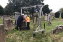 Inspectors lay a headstone flat in 2018