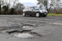 A car passing potholes on a road near Peterborough in Cambridgeshire. Photo: Joe Giddens/PA Wire