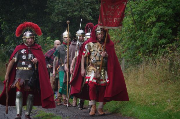 Peeblesshire News: The Antonine Guard visited West Linton last year to support campaigners against the quarry. They're photographed marching along the old Roman Road. Photo: Quarries Action Group