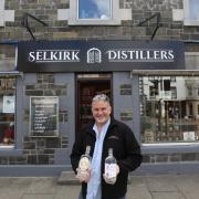 Owner of Selkirk Distillers Allan Walker at the business's new shop in Selkirk with their award winning Gins Selkirk Gin and Tilda's Tipple. Photo: Helen Barrington