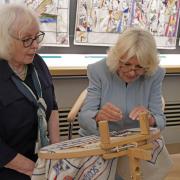 Great Tapestry of Scotland stitcher coordinator Dorie Wilke (left) watches Queen Camilla work on a commemorative tapestry during her visit to The Great Tapestry of Scotland visitor centre in Galashiels.